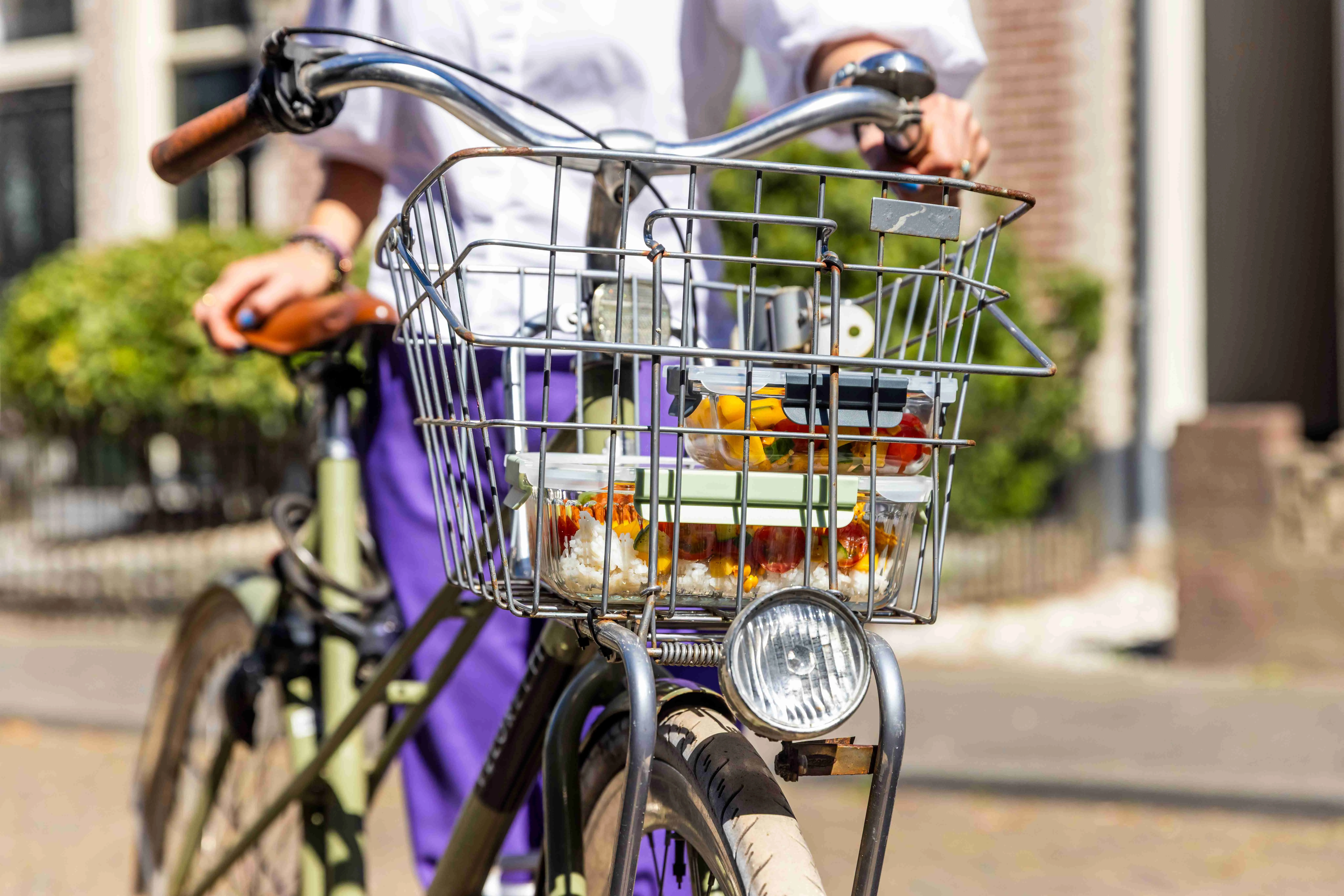 Fietsmandje gevuld met stapel maaltijdbakjes
